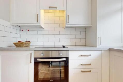 Bright and modern kitchen featuring sleek white...