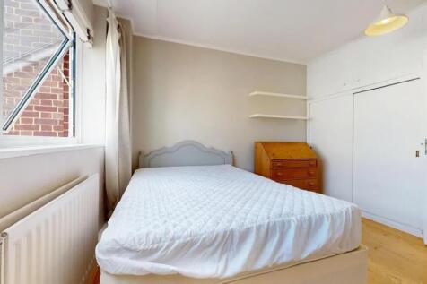 A bright double bedroom featuring a comfortable...
