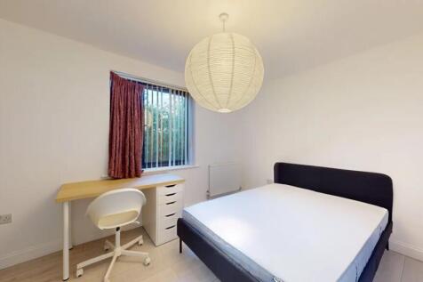 A neat and well-kept double bedroom featuring a...