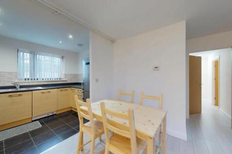 Bright and modern kitchen featuring a dining ta...