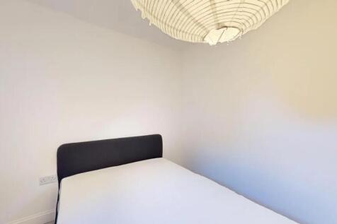 A simple and tidy double bedroom featuring a ne...