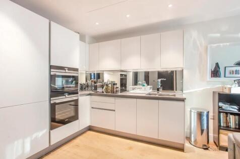 Modern and sleek kitchen featuring glossy white...