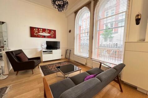 A stylish living room with large arched windows...