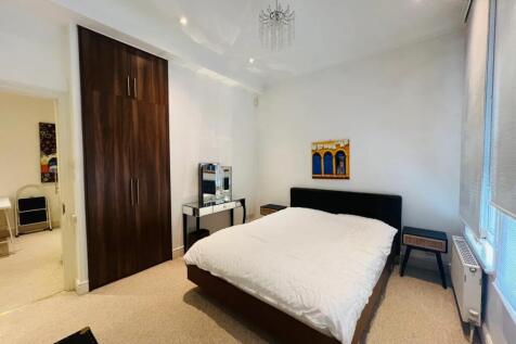 A neat and well-lit double bedroom featuring a ...