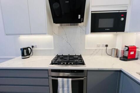 Modern kitchen featuring sleek white and gray c...