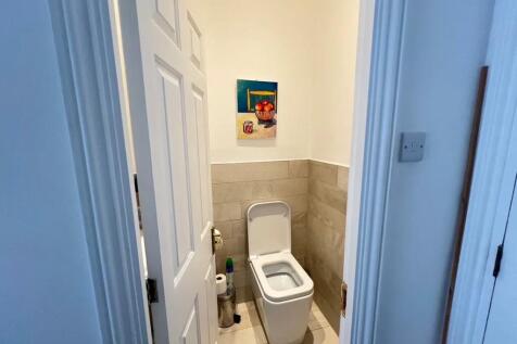 A clean and modern single toilet room featuring...