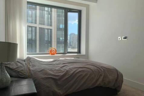 A bright double bedroom featuring a large windo...