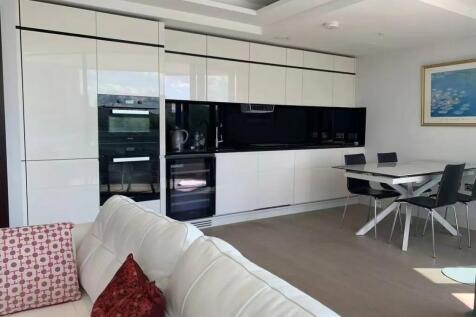 Modern kitchen area with sleek white cabinets a...