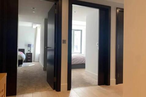 A clean and modern hallway featuring light wood...