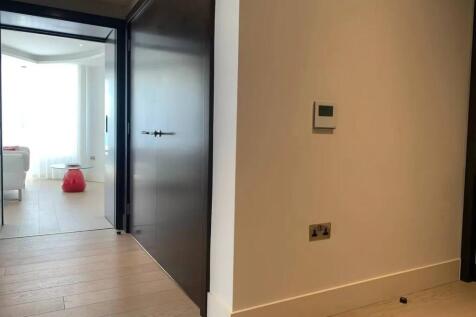 A modern hallway with light wooden flooring and...