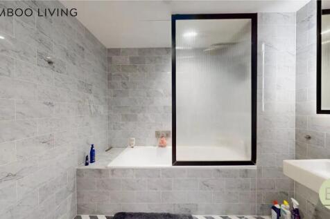 A modern bathroom suite featuring stylish grey ...