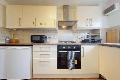 Bright and modern kitchen featuring clean white...