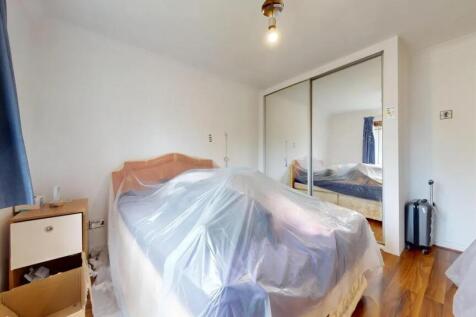 A well-lit double bedroom featuring a large bed...