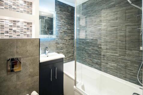 Modern bathroom suite featuring stylish grey ti...