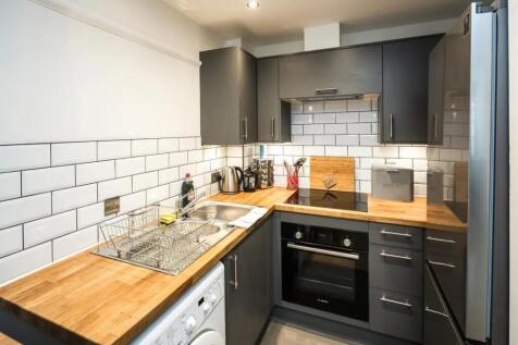 A modern and tidy kitchen featuring sleek dark ...