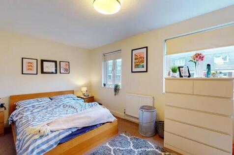 A bright, neatly arranged double bedroom featur...