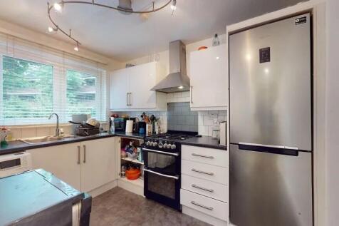 Bright and modern kitchen featuring sleek white...