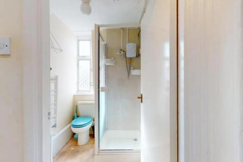 A compact bathroom featuring a walk-in shower w...