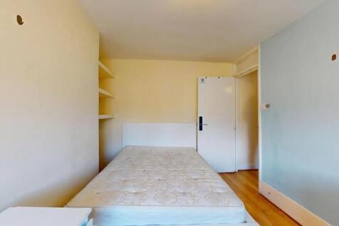 Compact bedroom featuring a clean mattress and ...