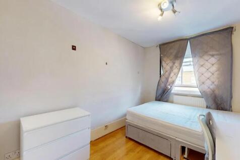 A tidy single bedroom featuring a comfortable b...
