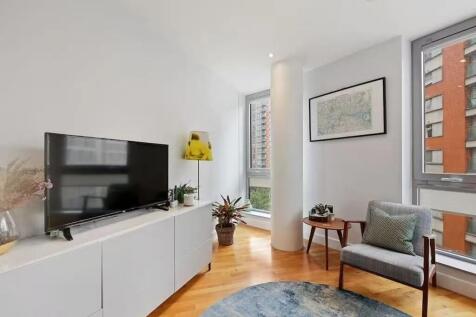 Bright and modern living room featuring large w...