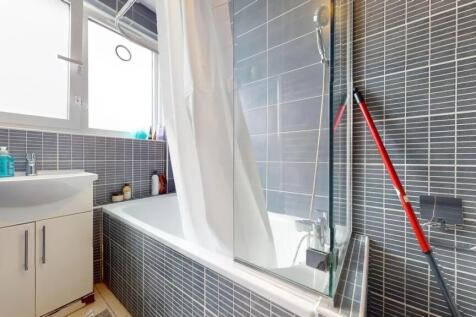 A modern bathroom suite featuring a bathtub wit...