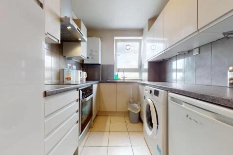 A clean and modern kitchen featuring white cabi...