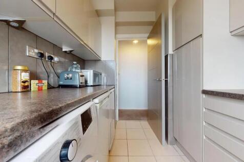 A clean and modern galley kitchen featuring sle...