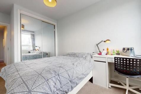 A tidy and well-lit bedroom featuring a comfort...