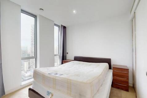 Bright double bedroom featuring two large windo...
