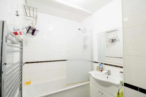 Bright and clean bathroom featuring a white bat...