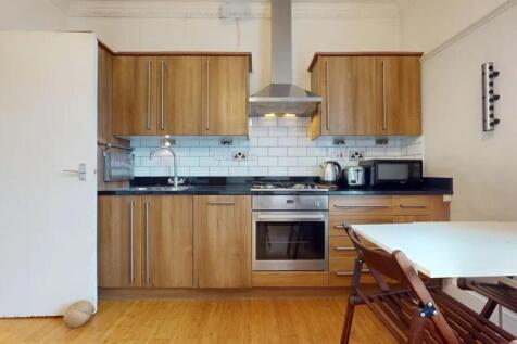 Modern kitchen space featuring wood-finish cabi...