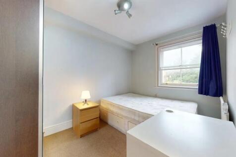 A neat and well-lit single bedroom featuring a ...