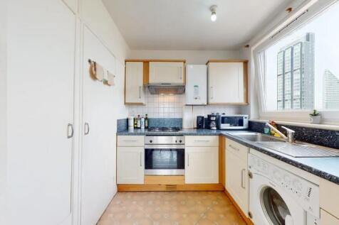 A bright and modern kitchen featuring clean whi...
