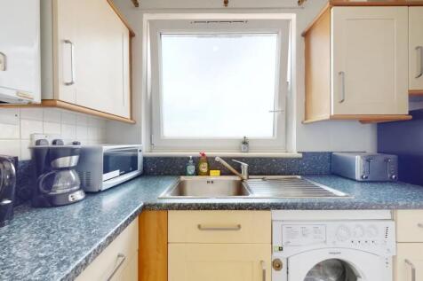 Bright and tidy kitchen featuring modern applia...