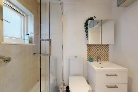 A modern bathroom featuring a clean white vanit...