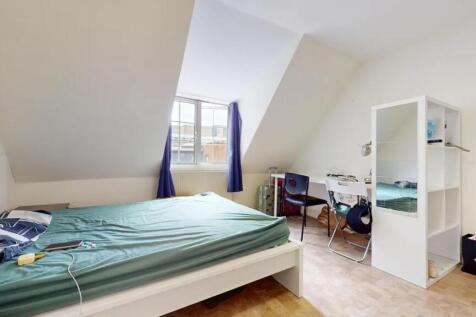 A bright double bedroom featuring a large windo...