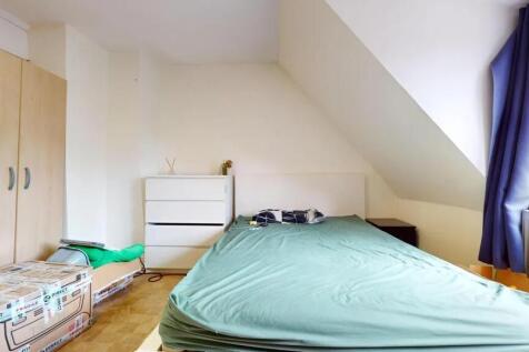 A cozy double bedroom featuring a large bed wit...