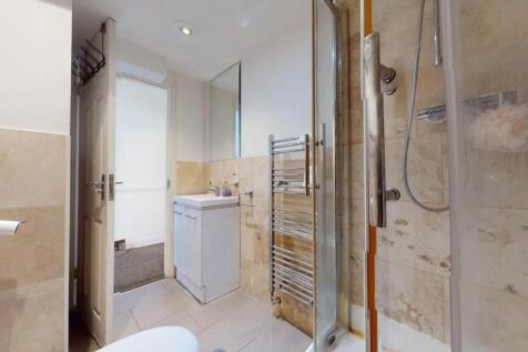 A modern bathroom featuring a clear glass showe...