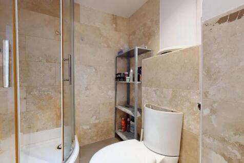 A modern bathroom featuring a curved glass show...