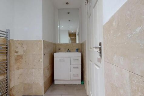 A clean and modern hallway featuring beige tile...