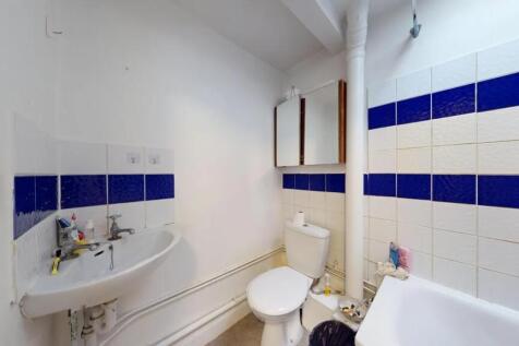 A compact bathroom featuring a white sink, toil...