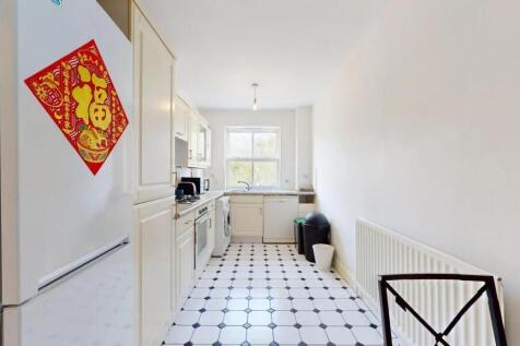 Bright and tidy kitchen featuring white cabinet...