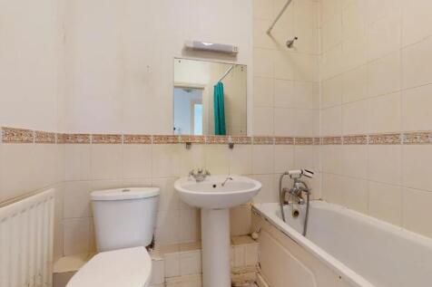 A compact bathroom featuring a white pedestal s...
