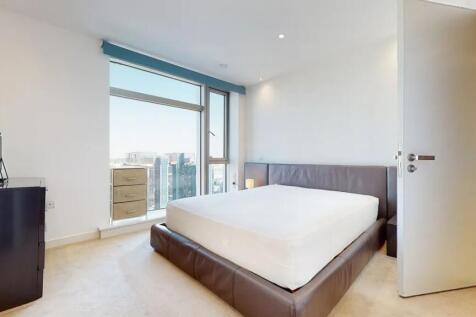 A modern master bedroom featuring a large leath...