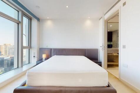 Bright and modern master bedroom featuring a la...