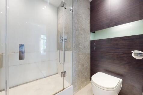Modern bathroom suite featuring a sleek glass-e...