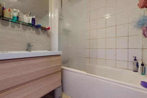 A functional bathroom suite featuring a bathtub...