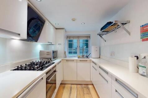A modern, well-lit kitchen featuring sleek whit...