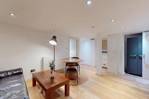 A modern living room featuring warm wooden floo...